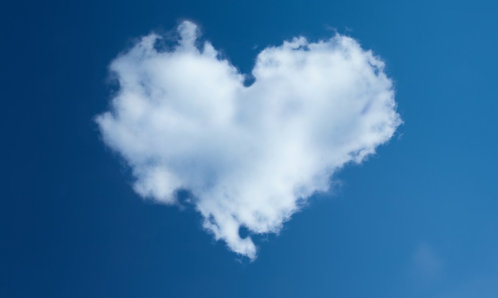 Heart-shaped cloud against a blue sky background